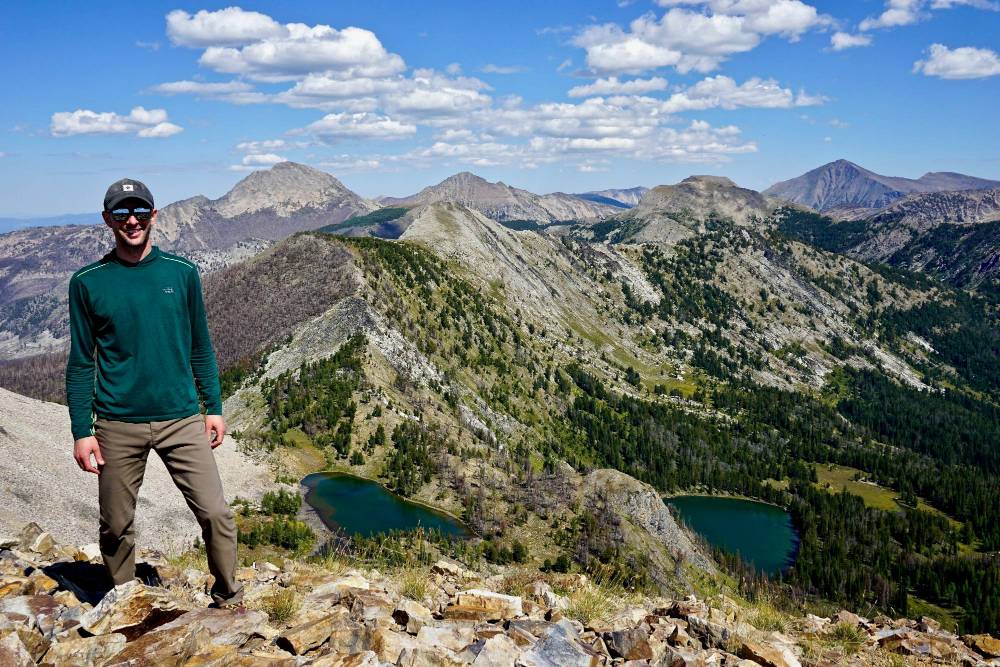 Man standing at the top of a mountain on a beautiful hike
